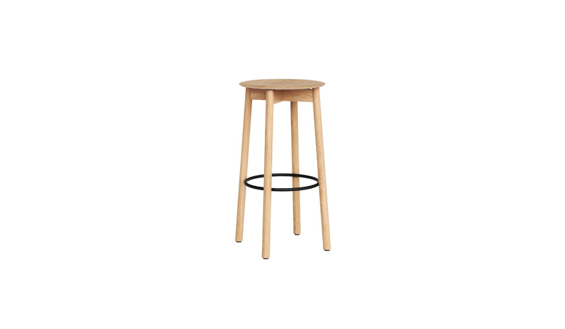 Tabouret de bar SSD en bois clair avec assise ronde et repose-pieds circulaire noir, sur fond blanc.