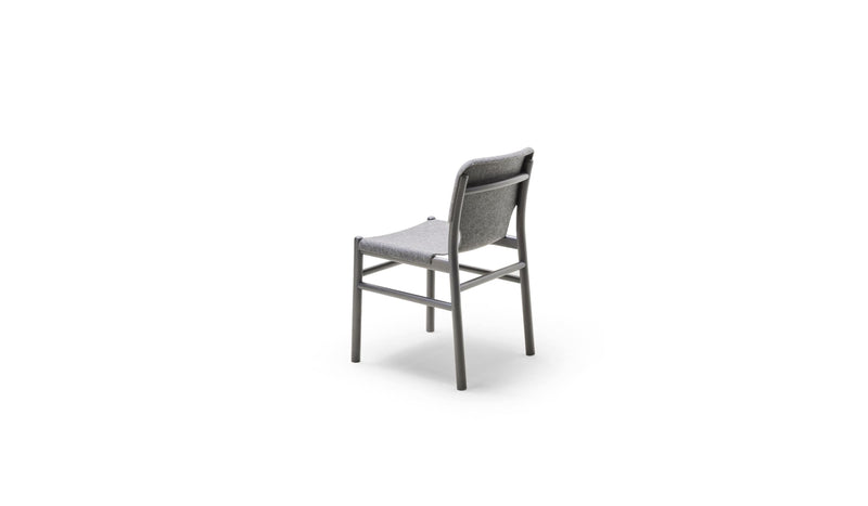 Chaise Alki en bois teinté gris avec assise et dossier en tissu gris, vue arrière trois quarts sur fond blanc.