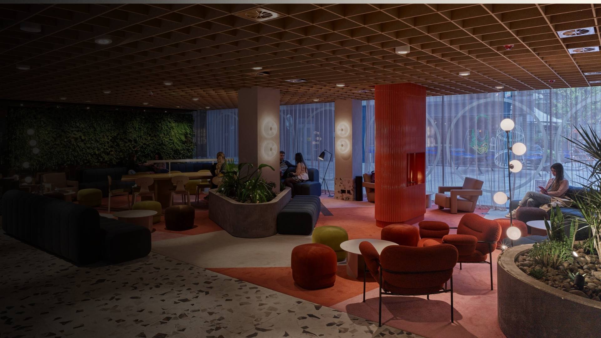 Espace lounge design avec mobilier coloré, murs végétalisés et éclairage tamisé dans une ambiance feutrée
