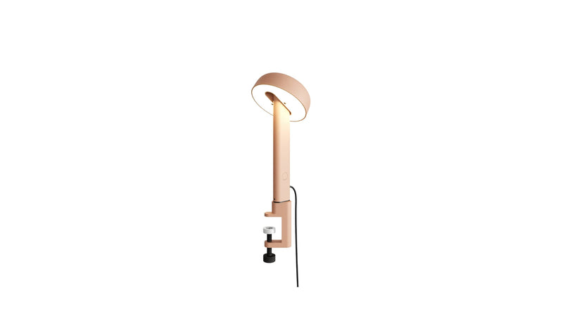 Lampe à pince rose, Nod de Tiptoe, vue latérale avec l’ampoule allumée, abat-jour circulaire.