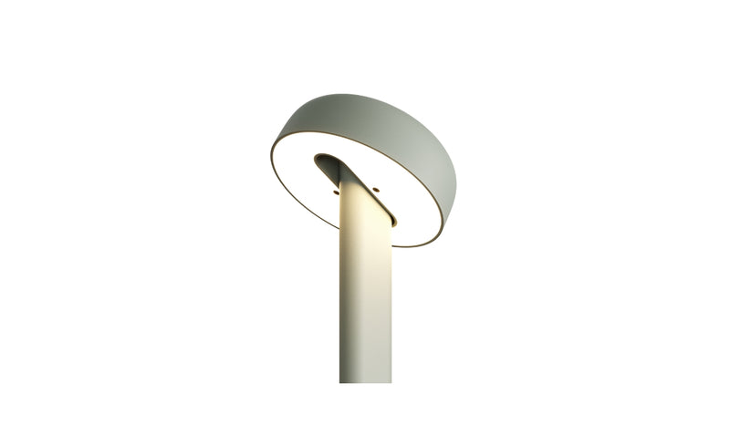 Gros plan sur la tête de la lampe de table Nod en métal gris eucalyptus, allumée