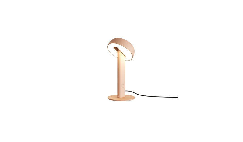 Lampe de table Nod en métal rose, base ronde et tête inclinée, allumée