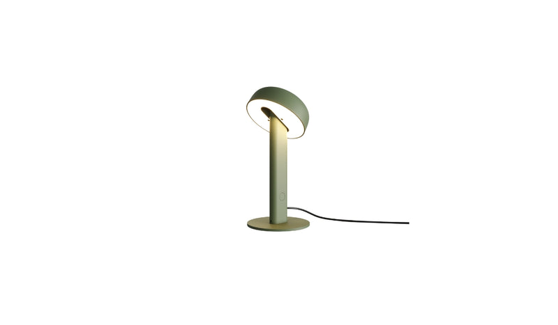 Lampe de table Nod en métal vert, base ronde et tête inclinée, allumée