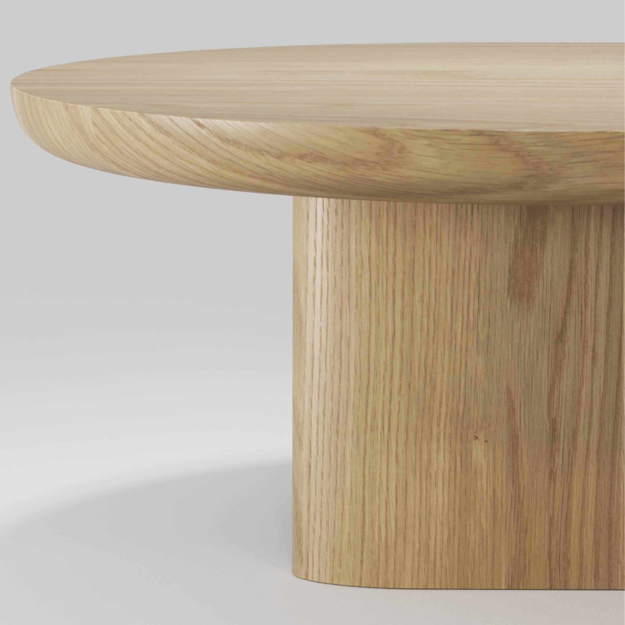 Détail du plateau arrondi et du pied cylindrique en chêne massif de la table basse Re‑Form Wewood, sur fond neutre.