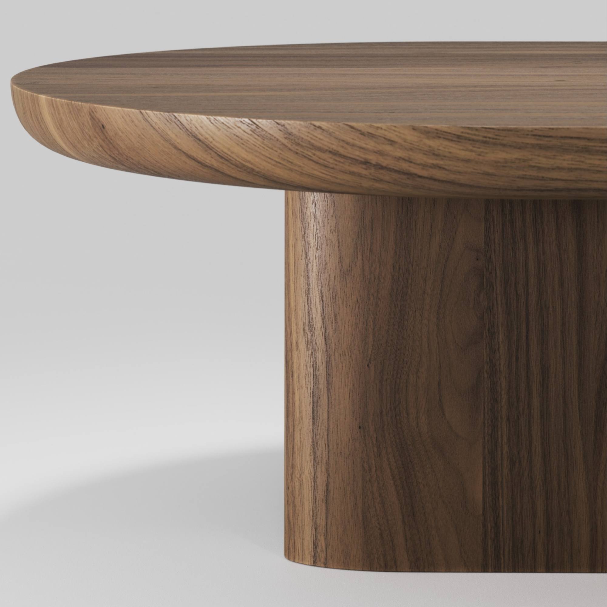 Détail du plateau arrondi et du pied cylindrique en noyer massif de la table basse Re‑Form Wewood, sur fond neutre.