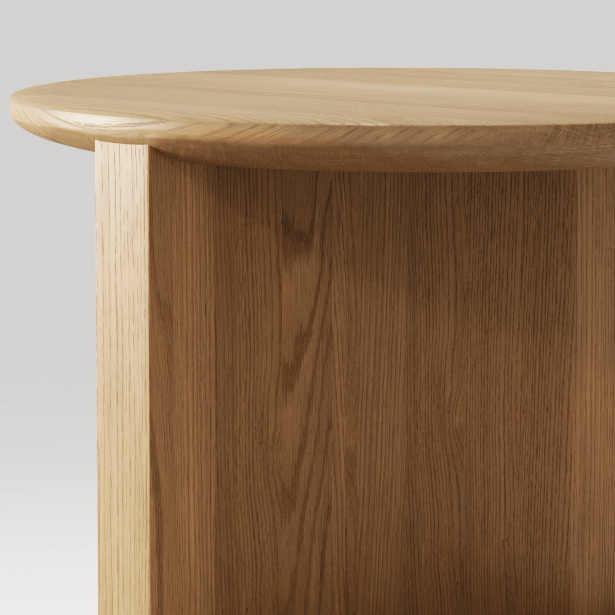 Zoom sur le plateau arrondi en chene massif et les finitions soignées de la table Duplex