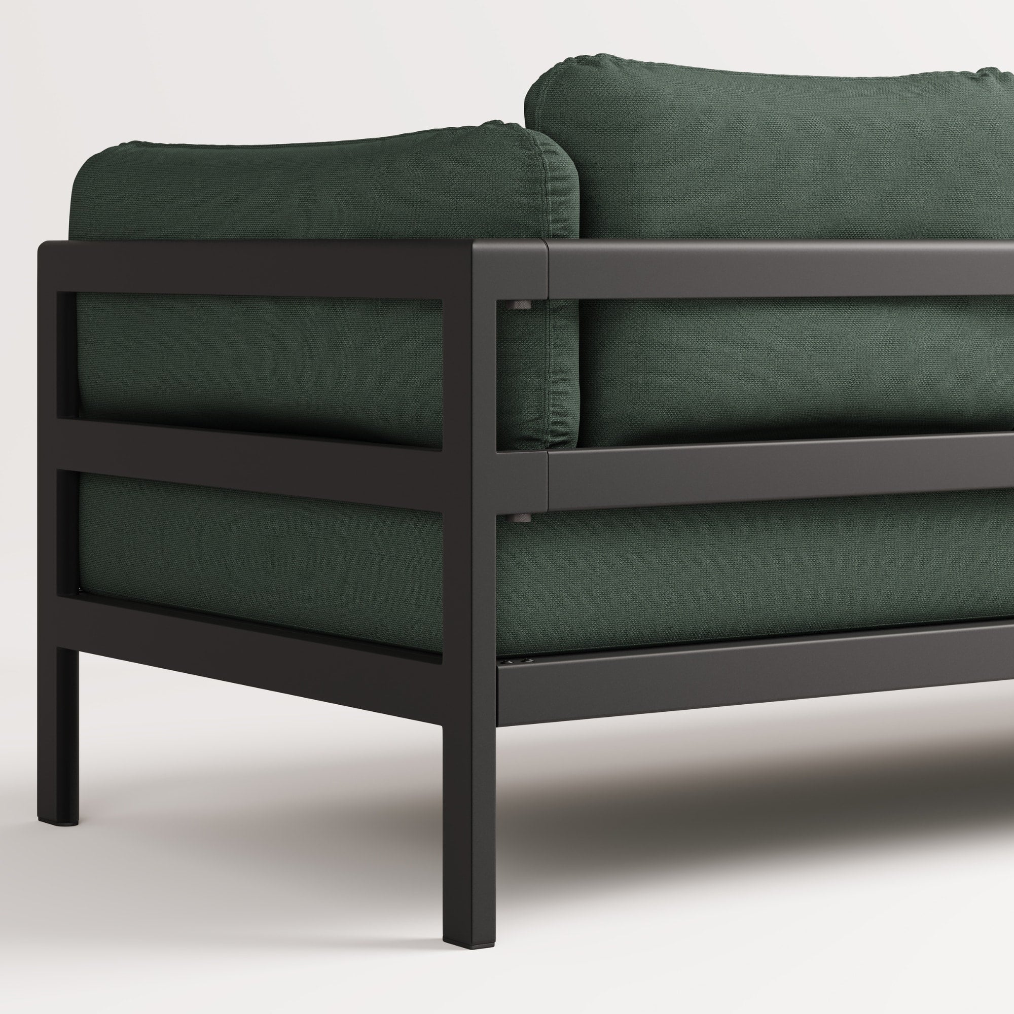 Vue arrière, gros plan du canapé Easy de Tiptoe en tissu vert avec structure en métal noir, mettant en avant ses coussins épais et son design épuré.