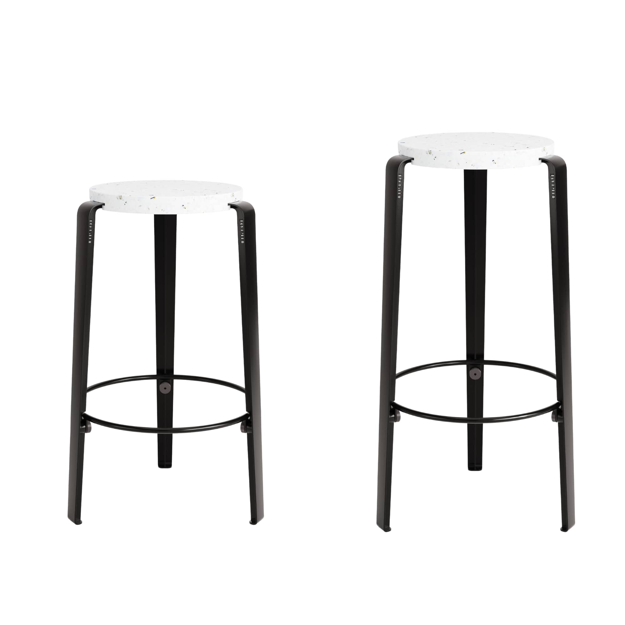 Deux tabourets de bar noirs en acier avec assise en plastique recyclé blanc, au design épuré et durable.