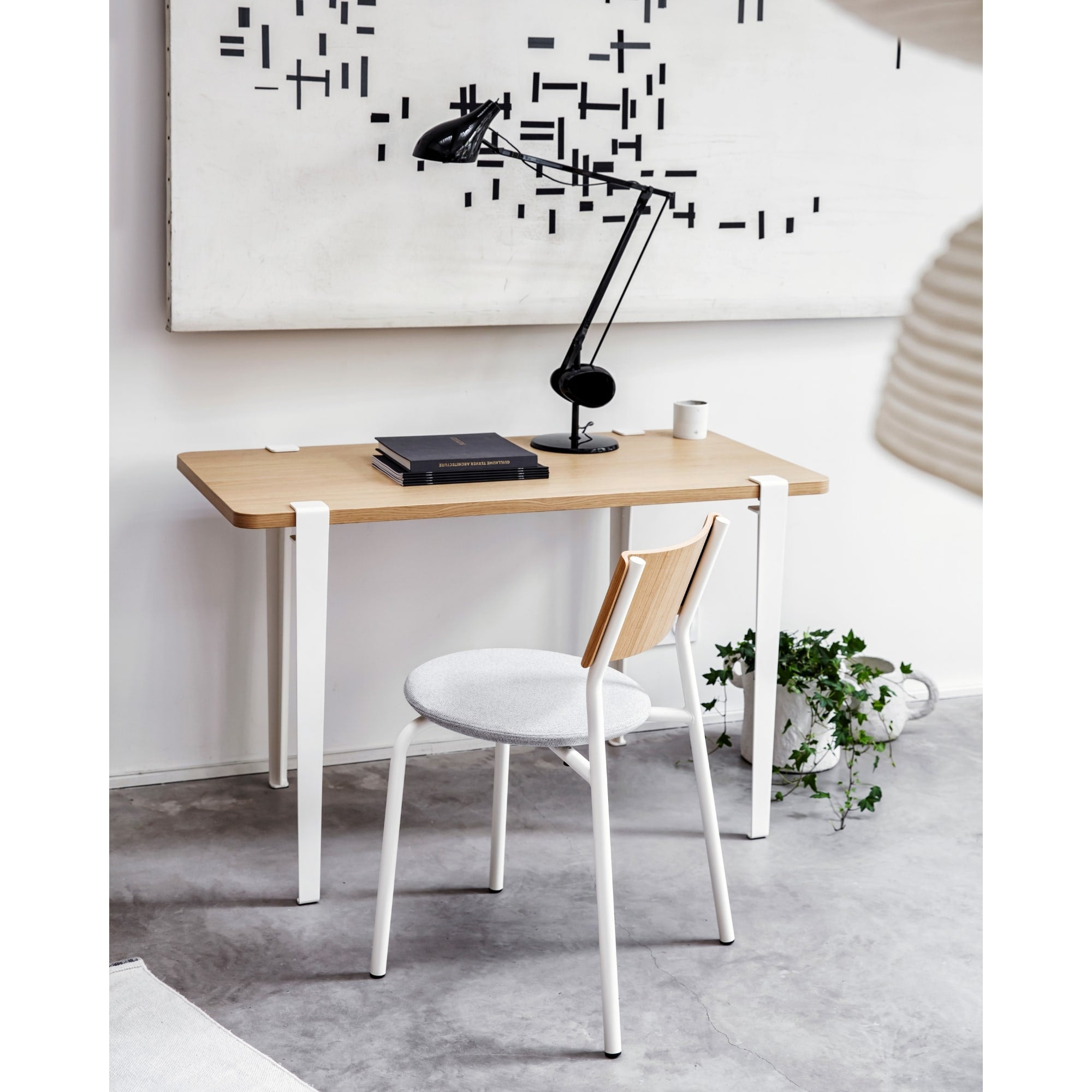Chaise SSD Soft de Tiptoe avec piètement blanc, dossier en bois et assise en tissu clair, placée devant un bureau en bois clair dans un intérieur contemporain.