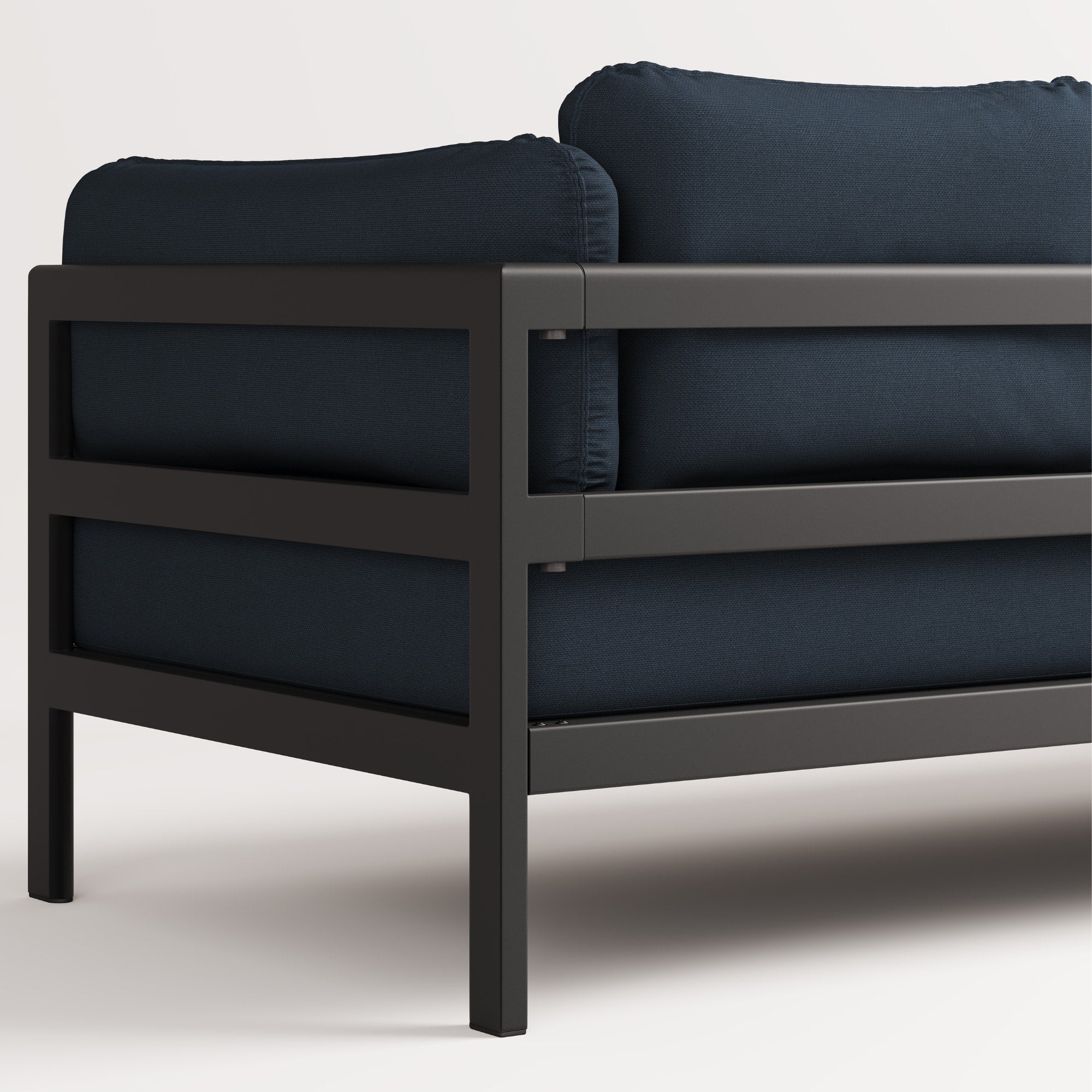 Vue arrière, gros plan du canapé Easy de Tiptoe en tissu bleu avec structure en métal noir, mettant en avant ses coussins épais et son design épuré.