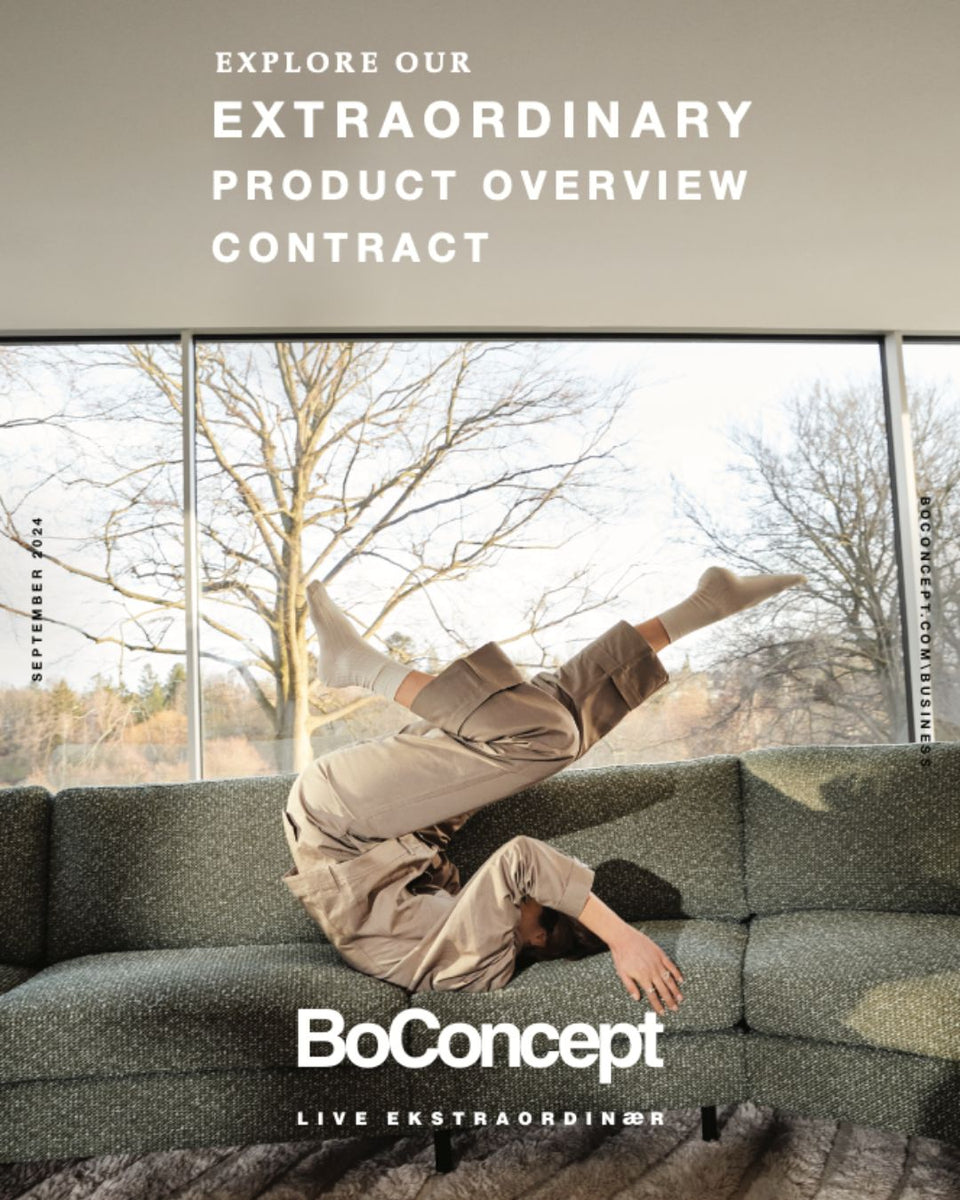 Catalogue BoConcept septembre 2024 avec une personne en équilibre sur un canapé vert, devant une baie vitrée et des arbres nus