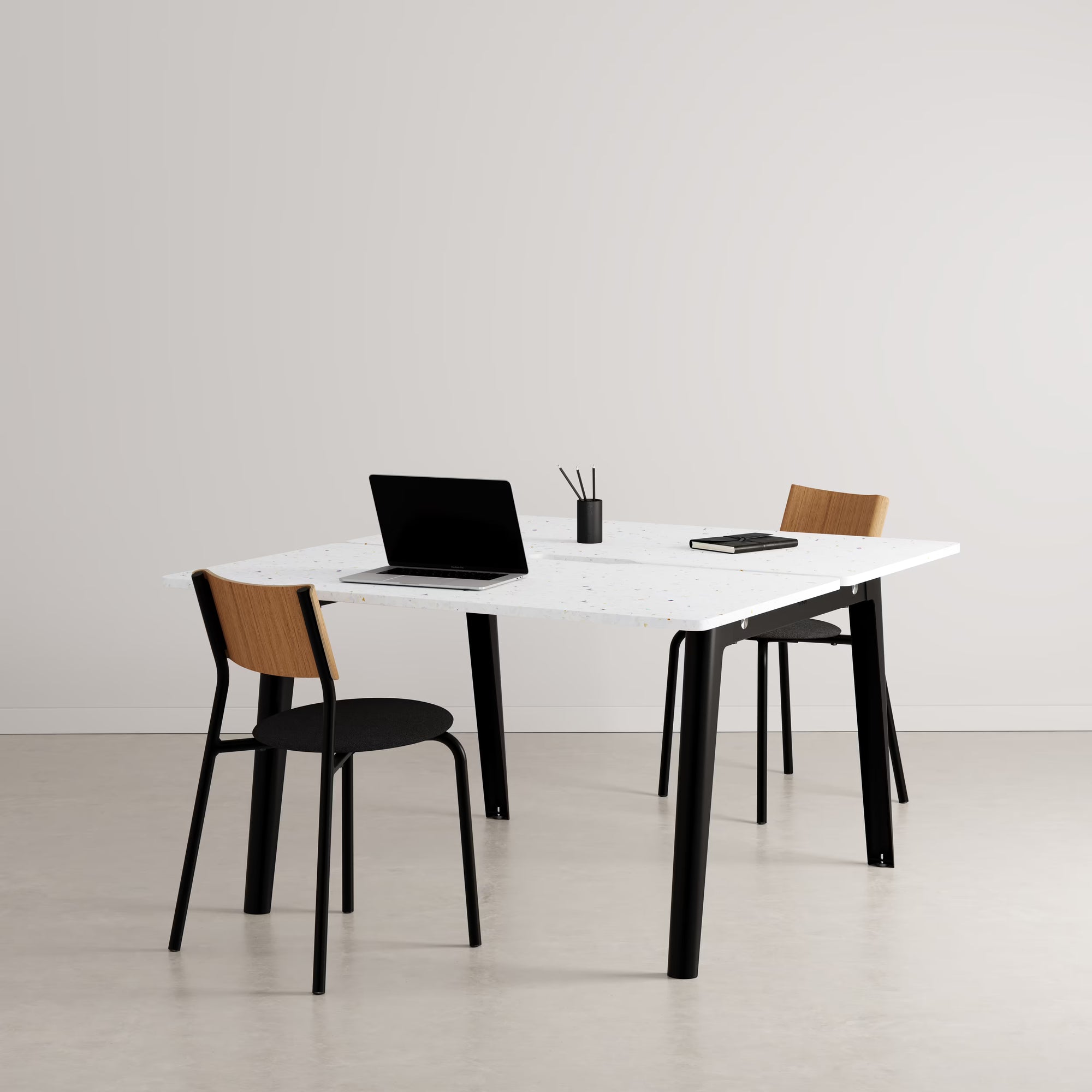 Bureau partagé rectangulaire plateau blanc avec pieds noirs, présenté avec chaises assorties et accessoires sur fond neutre