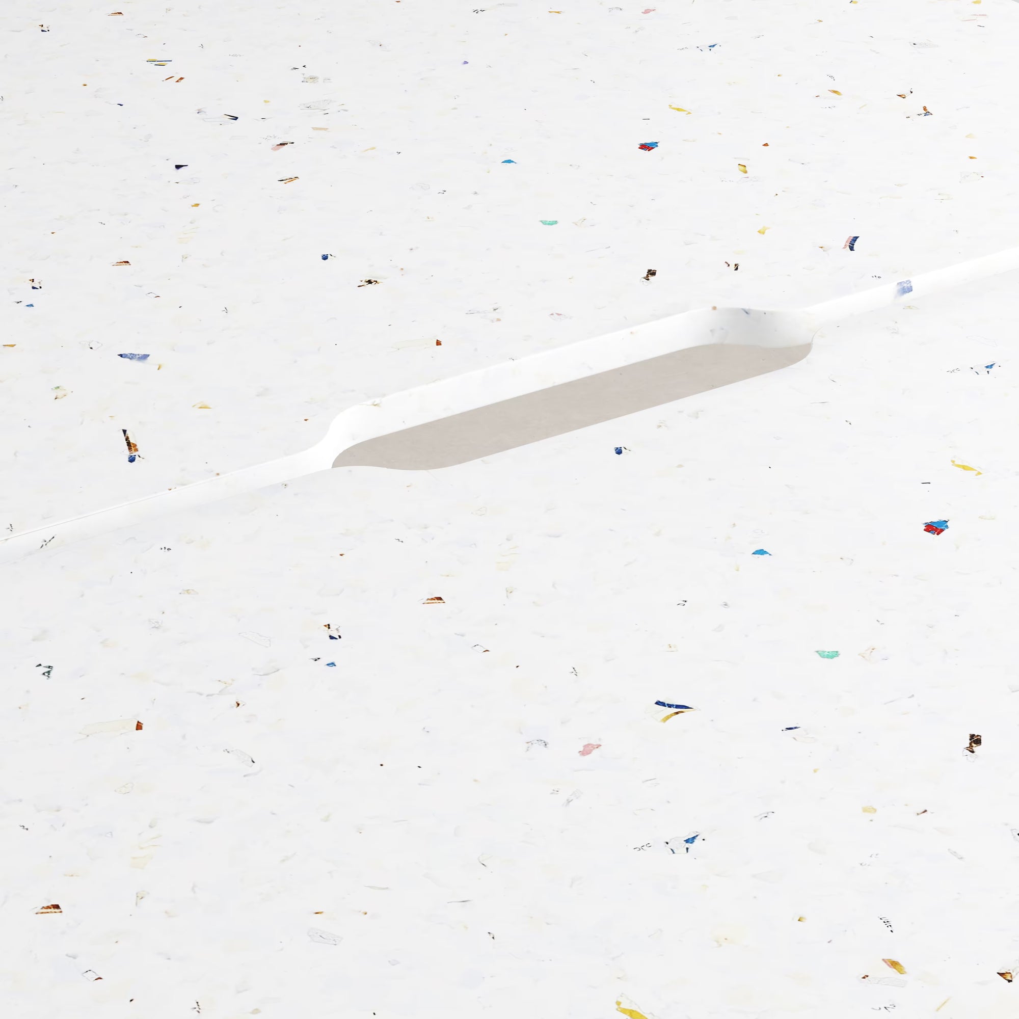 Gros plan sur un plateau blanc moucheté en plastique recyclé, avec fente passe-câbles ovale intégrée au centre.