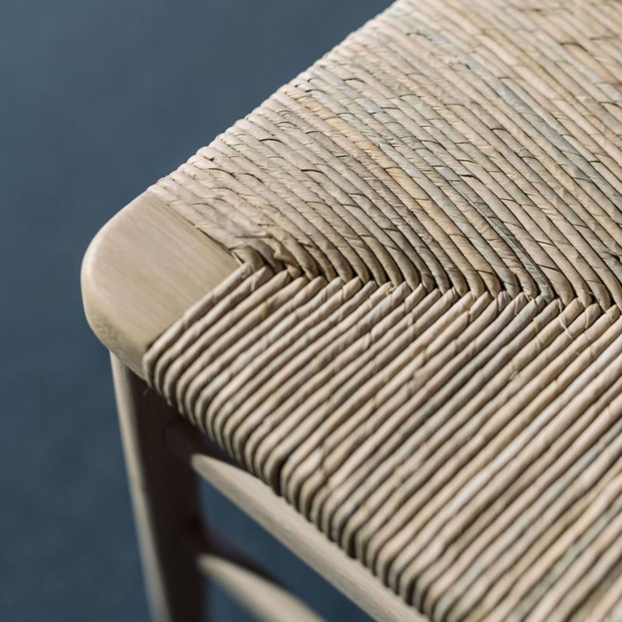 Détail de l’assise en paille du tabouret de bar Kimua en chêne, tressage fin et structure en bois clair