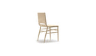Chaise Kimua de la marque Alki en chêne massif et assise en paille, vue de trois quarts sur fond blanc