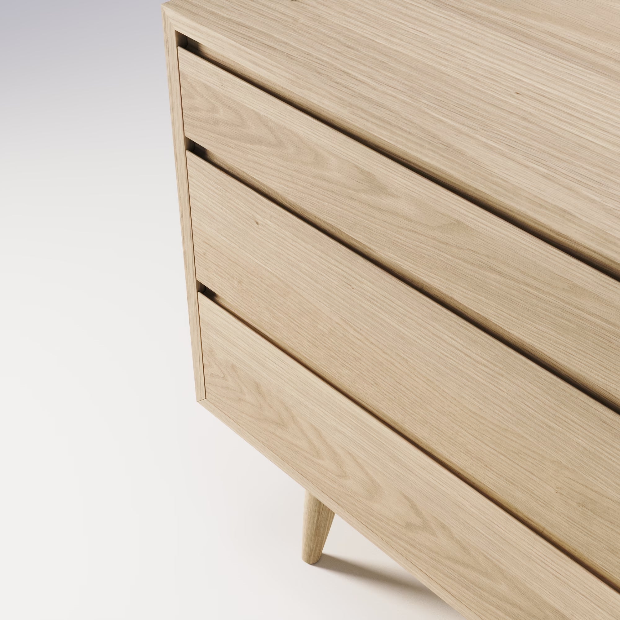 Zoom sur la commode Double Wewood en chêne, détail des tiroirs sans poignées et du veinage du bois, vue de trois quarts bas