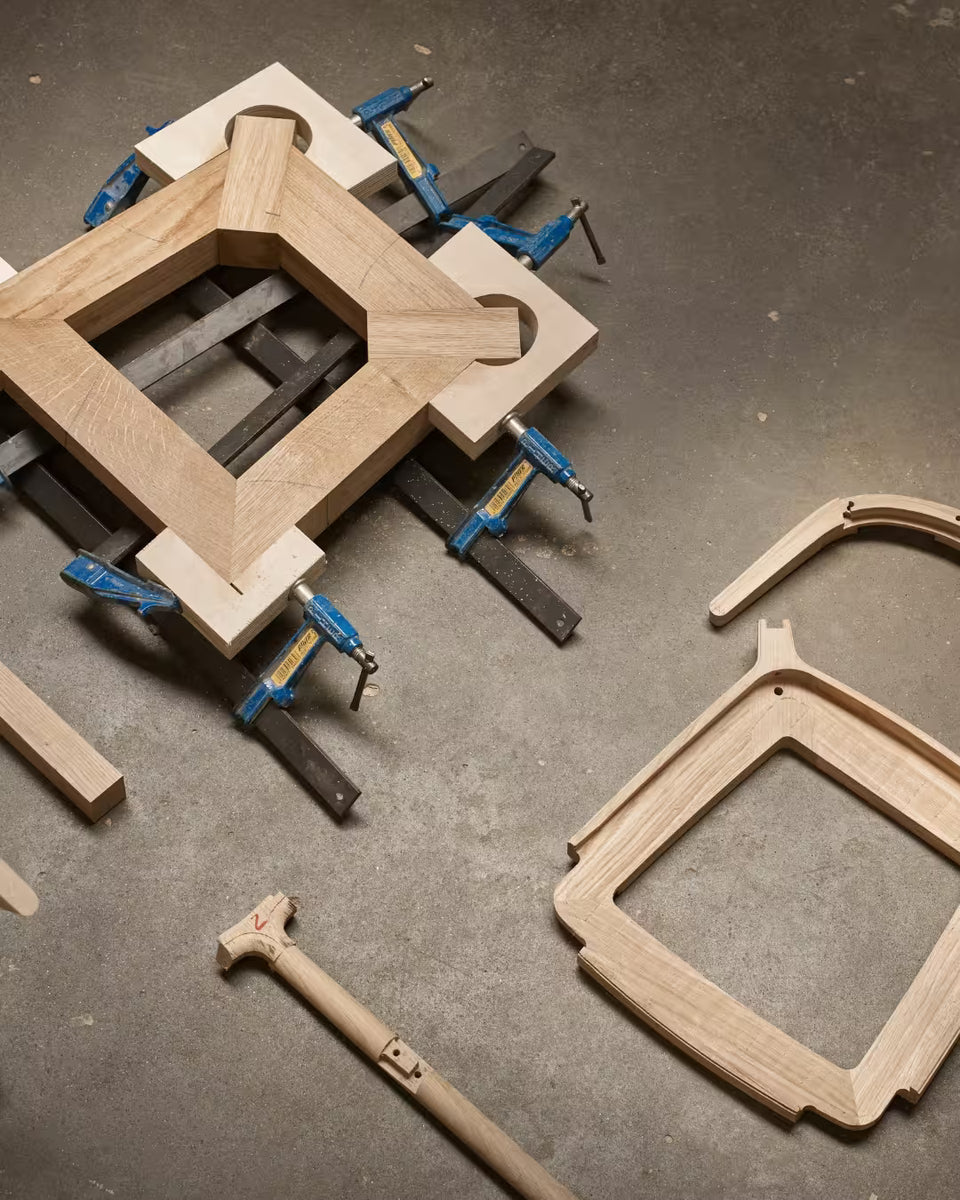 Éléments de chaise en bois en cours d’assemblage dans un atelier, illustrant une conception modulaire et réparable.
