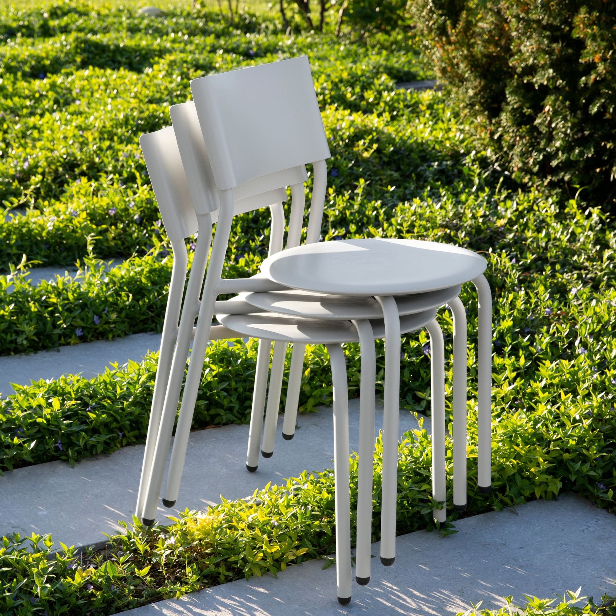 Chaises empilables en métal et plastique recyclé gris clair, design minimaliste et structure légère, modèle SSDr Tiptoe.