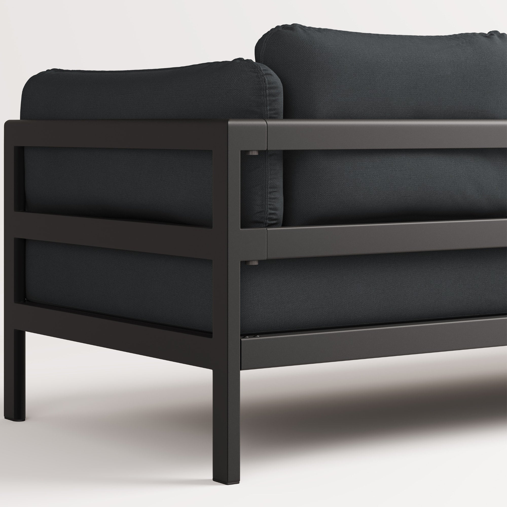 Vue arrière, gros plan du canapé Easy de Tiptoe en tissu noir avec structure en métal noir, mettant en avant ses coussins épais et son design épuré.