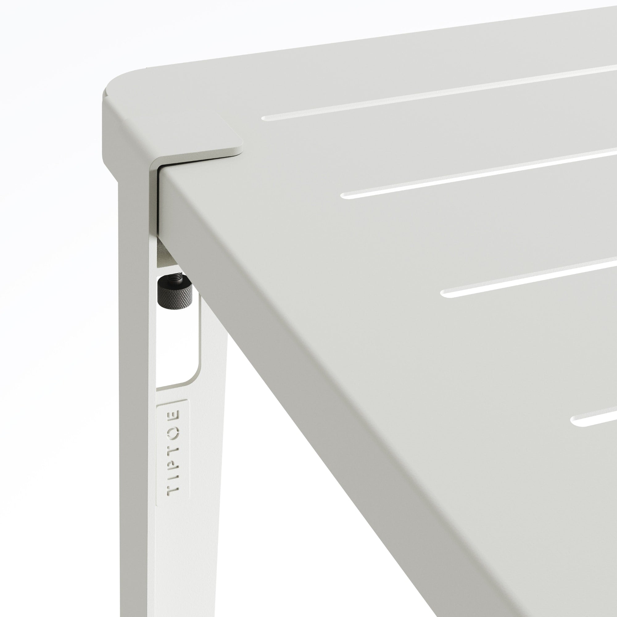 Zoom sur l’angle de la table de jardin Tiptoe en métal gris craie, montrant le système de fixation du pied et les rainures du plateau.