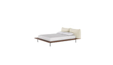 Lit Platform de Wewood en bois massif de noyer, avec tête de lit textile intégrée, vu de trois quarts sur fond blanc