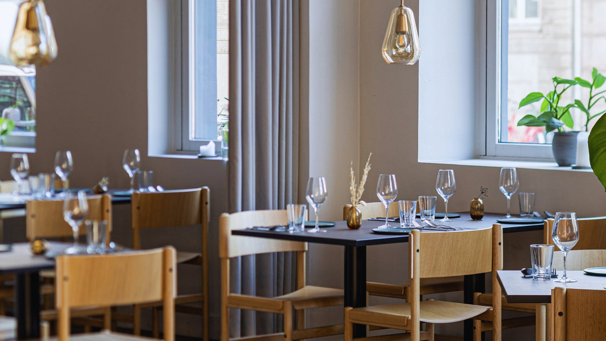 salle de restaurant avec du mobilier design incluant des chaises et des tables avec des supensions lumineuses