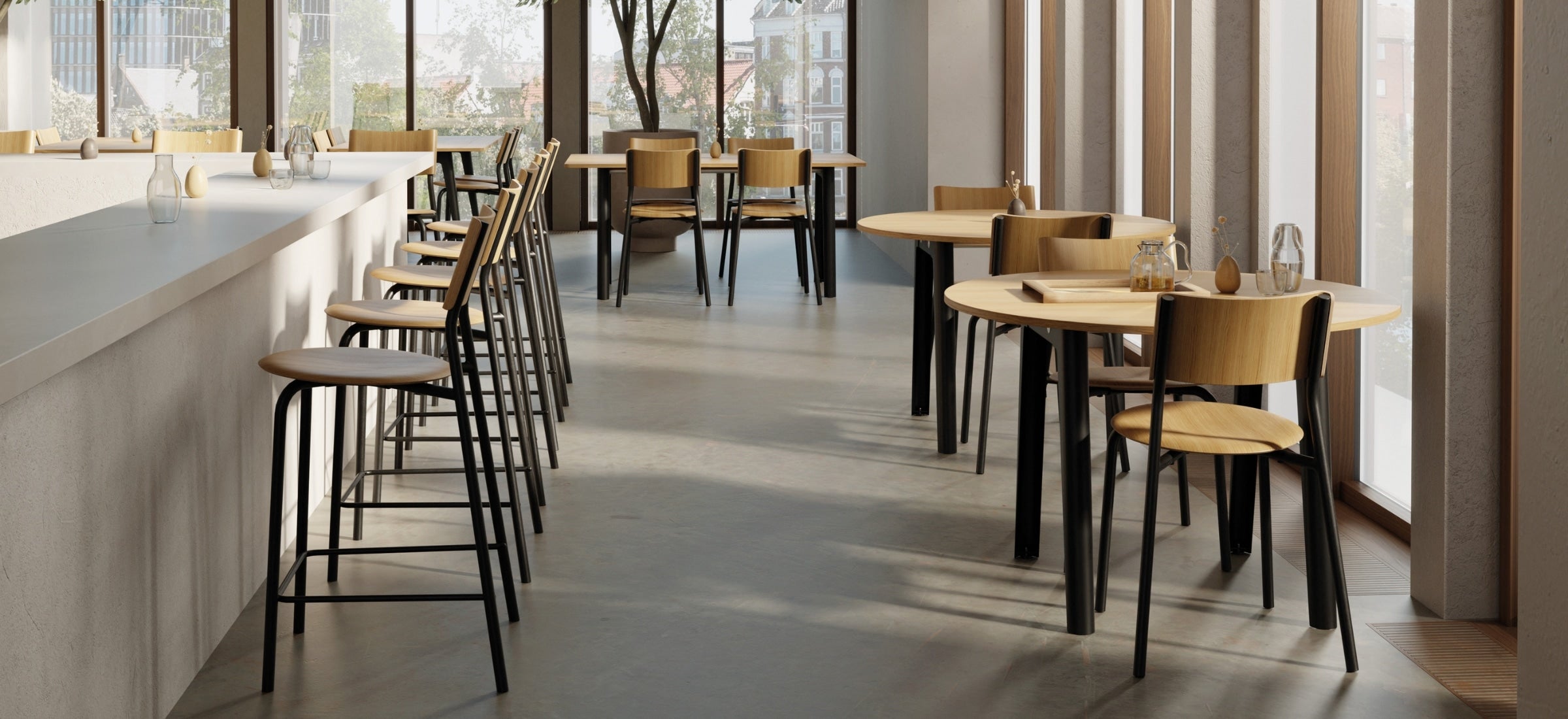 Chaises hautes alignées le long d’un comptoir clair dans un café moderne et lumineux, ambiance épurée avec grande baie vitrée.