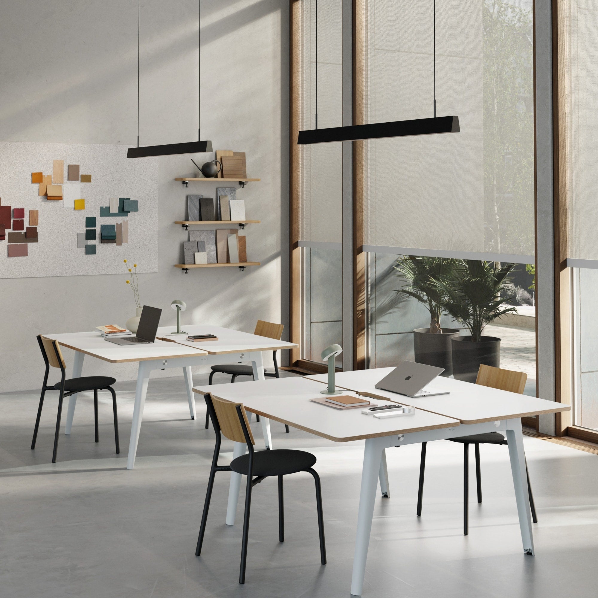 Espace de travail lumineux avec des chaises SSD Soft Tiptoe à structure noire, dossier bois clair et assise tissu noir, autour de bureaux blancs.