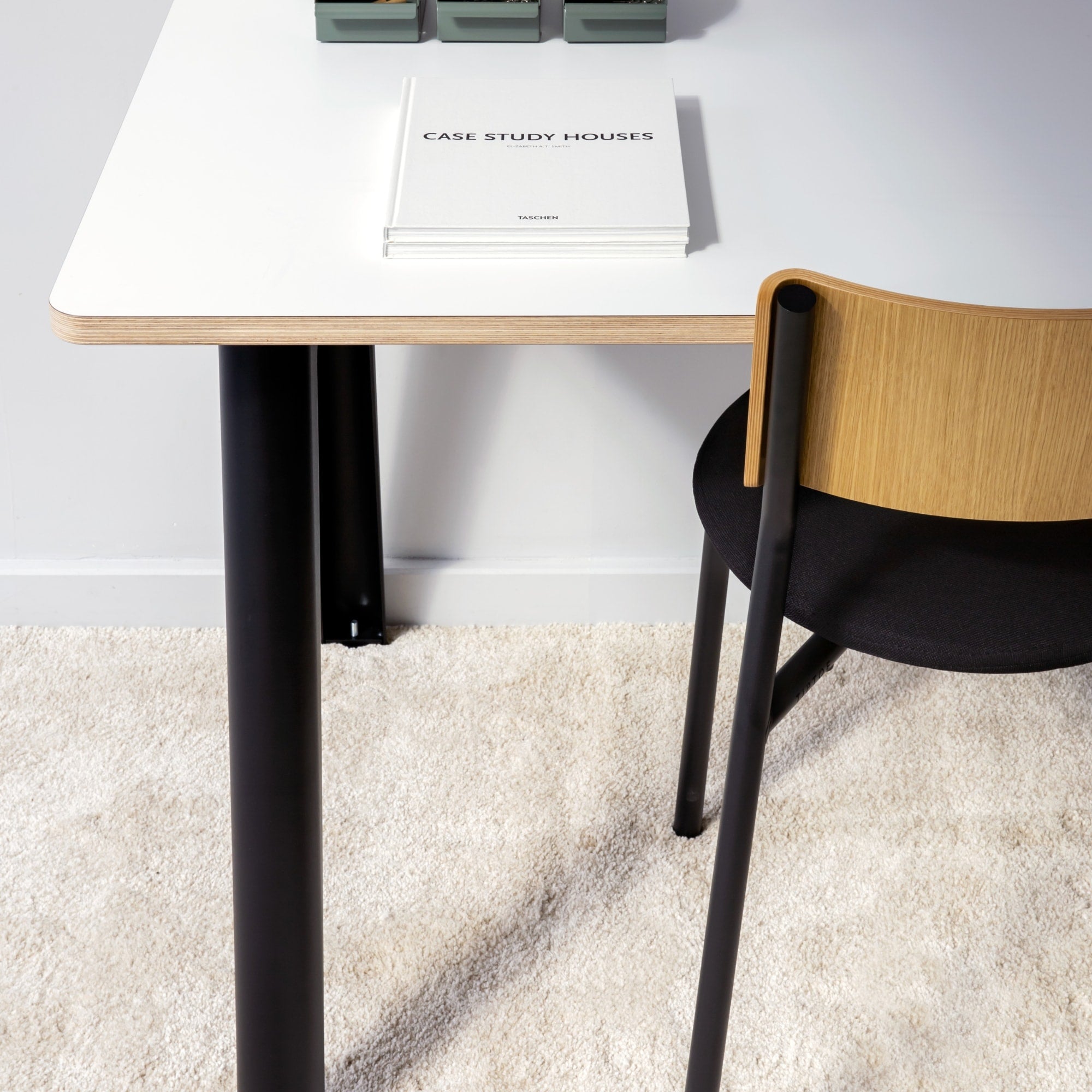 Chaise SSD Soft Tiptoe avec piètement noir, assise tissu noir et dossier bois clair, placée sous un bureau blanc sur tapis beige.