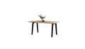 Table rectangulaire pour 6 personnes en chêne clair avec pieds noir, décorée d’un bouquet de fleurs.
