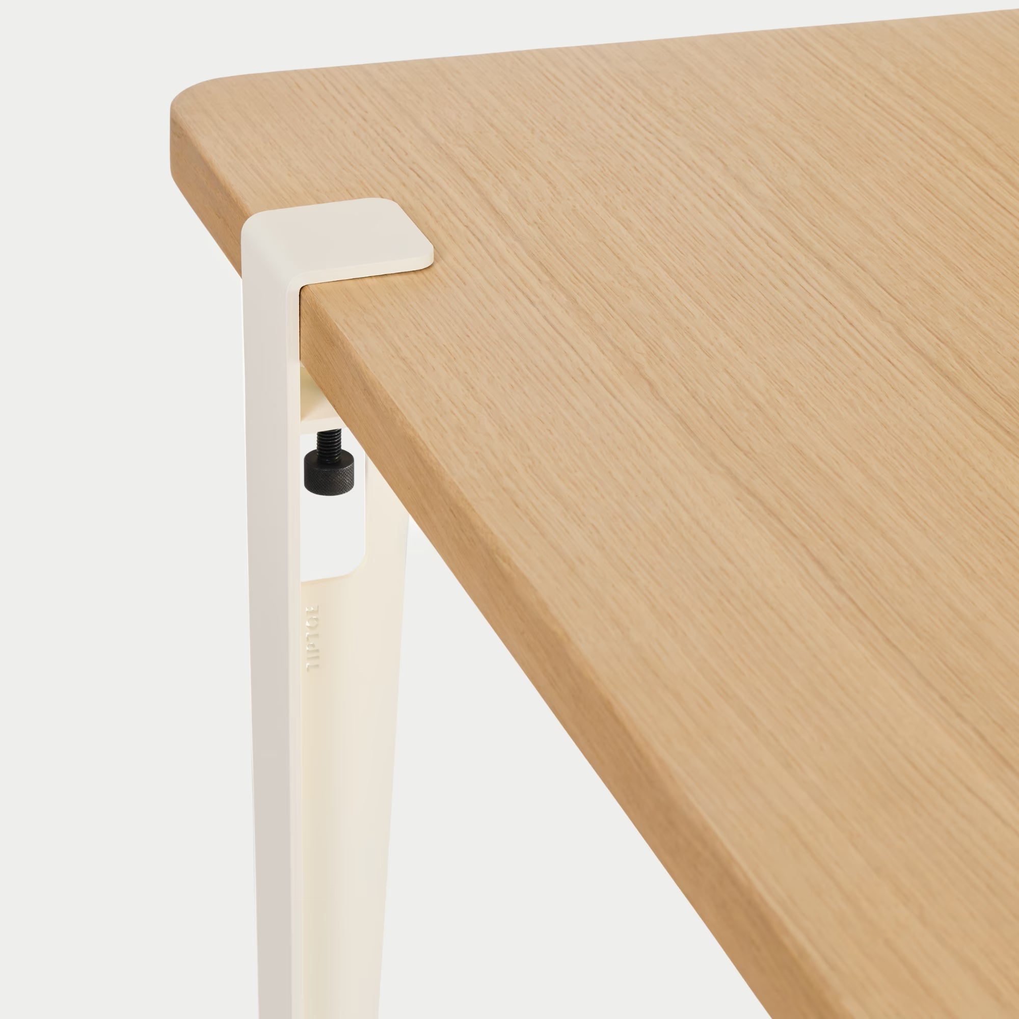 Vue rapprochée : plateau bois clair et fixation métal blanc crème, détail de l’assemblage sur fond blanc.