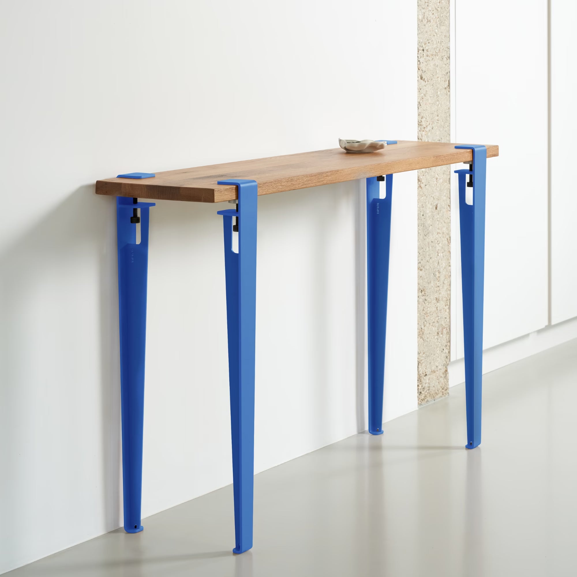 Console en bois massif avec piètement métallique bleu azur TIPTOE, adossée à un mur blanc dans un intérieur moderne.