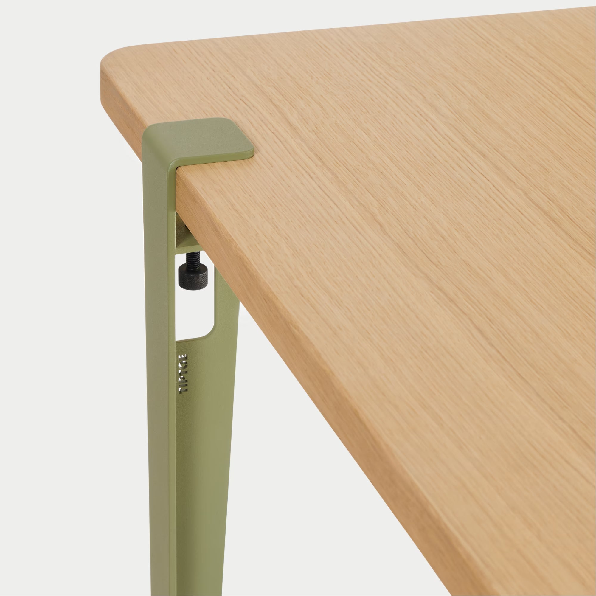 Vue rapprochée : plateau bois clair et fixation métal vert kaki, détail de l’assemblage sur fond blanc.