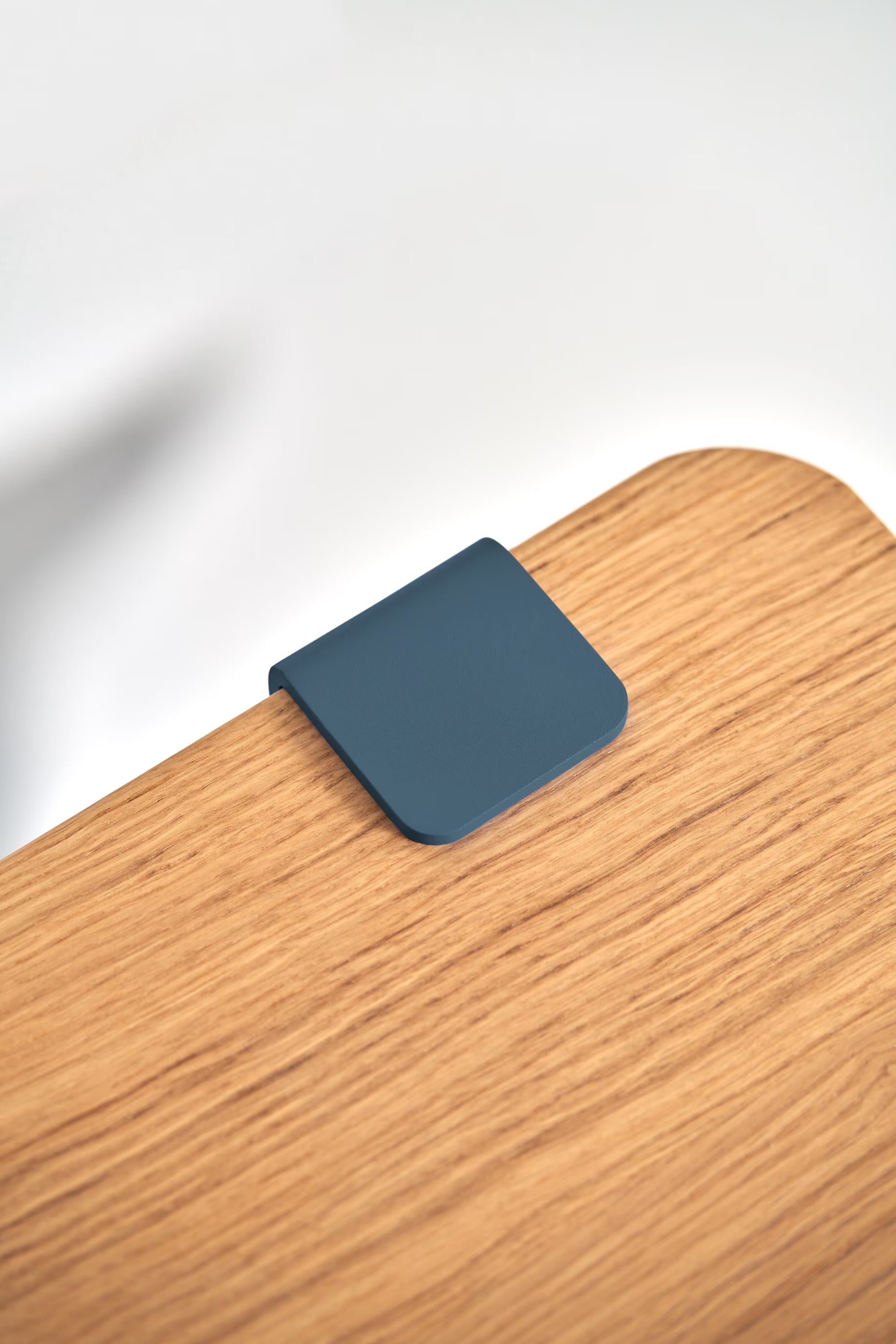 Gros plan sur le plateau en bois massif avec fixation métallique bleu nuit, texture et détail visibles.