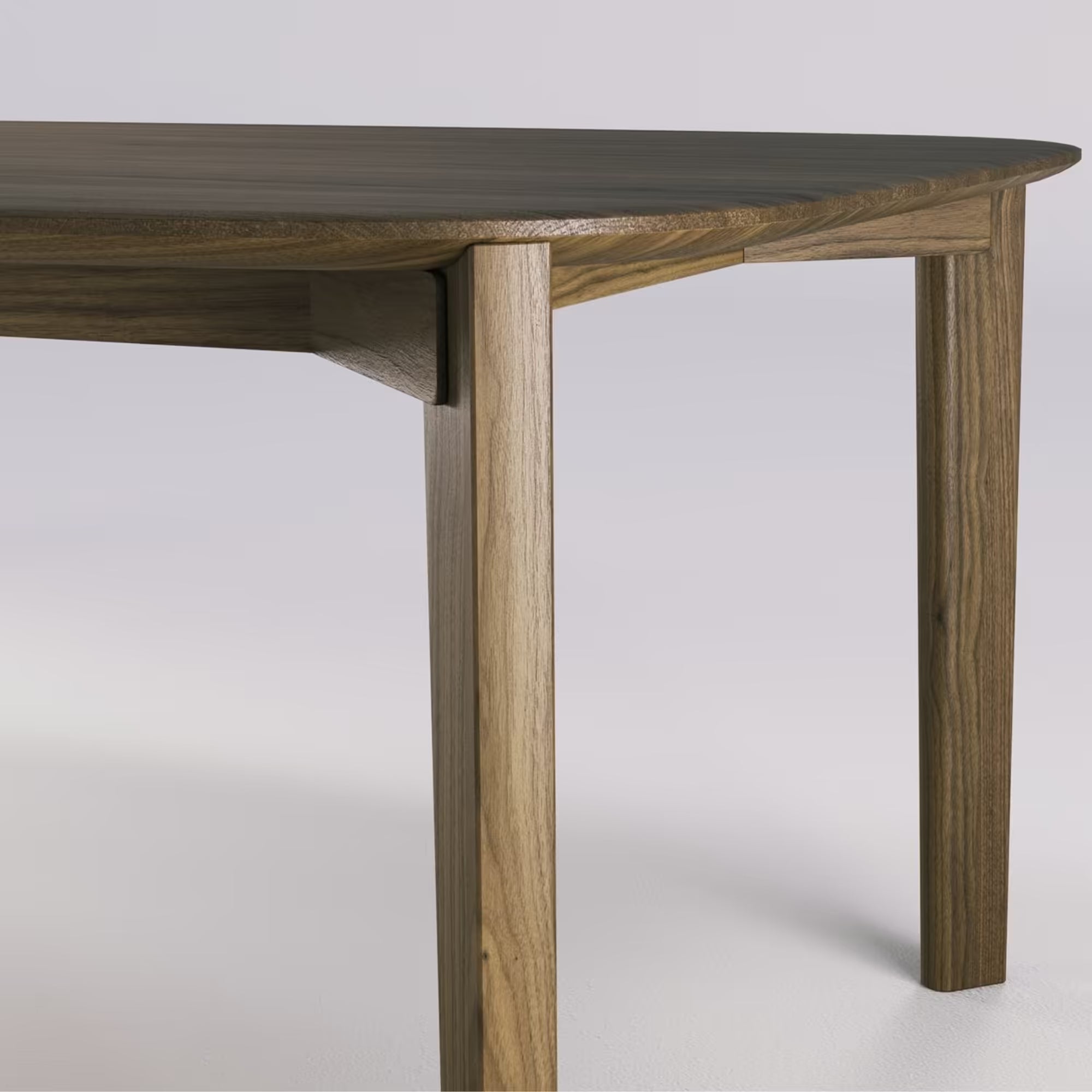Zoom sur les pieds et l’assemblage en noyer massif de la table Soma de WeWood, sur fond blanc