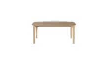 Vue en légère plongée de la table Soma 240 cm en chêne massif, plateau ovale et structure fine, 8 à 10 places sur fond blanc