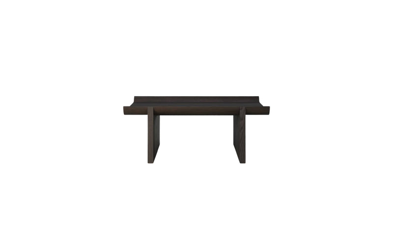 Table basse Rigoles de WeWood en chêne brun, vue de face sur fond blanc, piètement géométrique et plateau incurvé