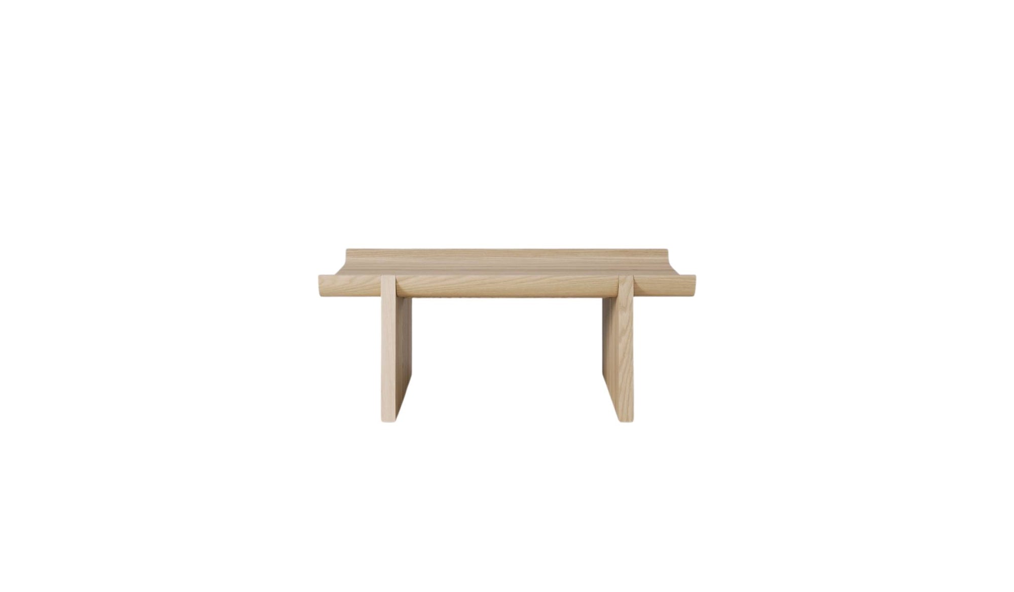 Table basse Rigoles de WeWood en chêne naturel, vue de face sur fond blanc, piètement géométrique et plateau incurvé