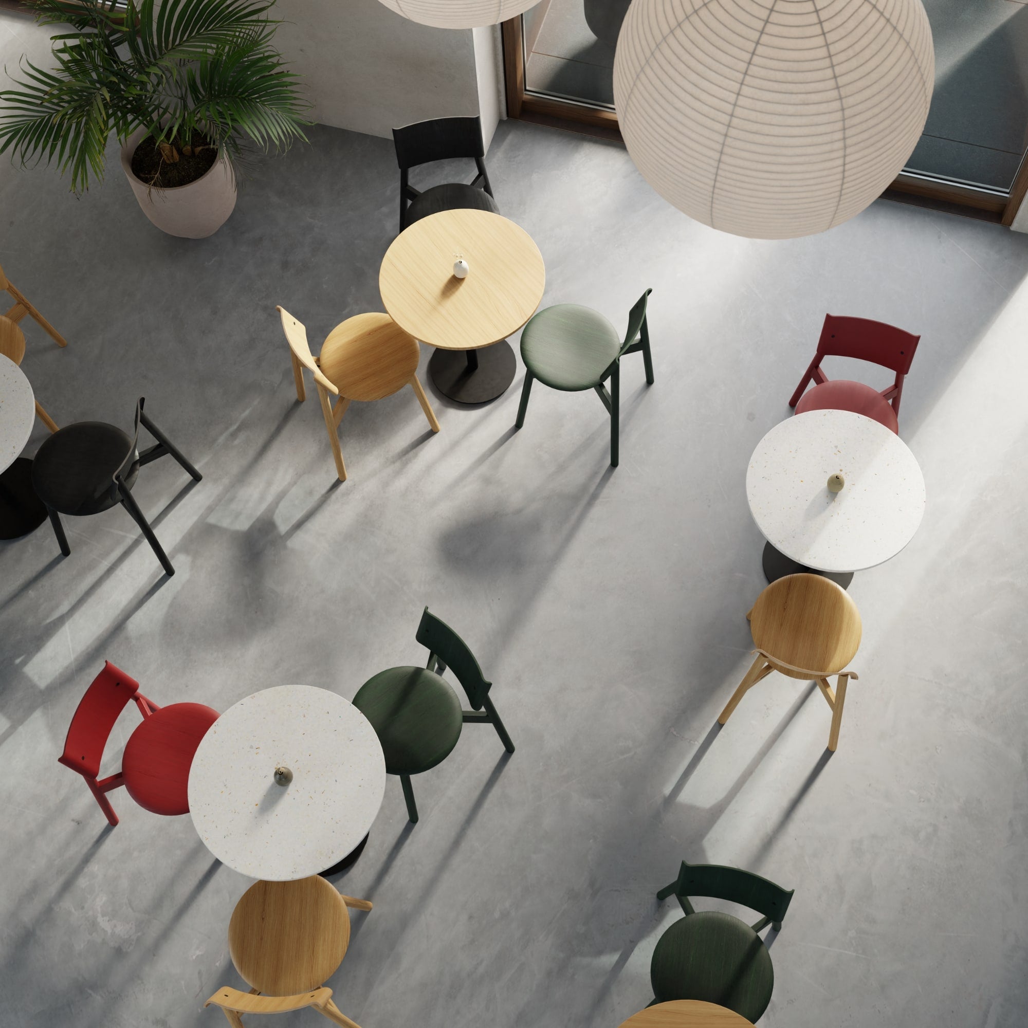 Vue plongeante d’un espace café aménagé avec des tables bistrot Moka et des chaises SSD Tiptoe en bois et couleurs vives sur sol en béton.
