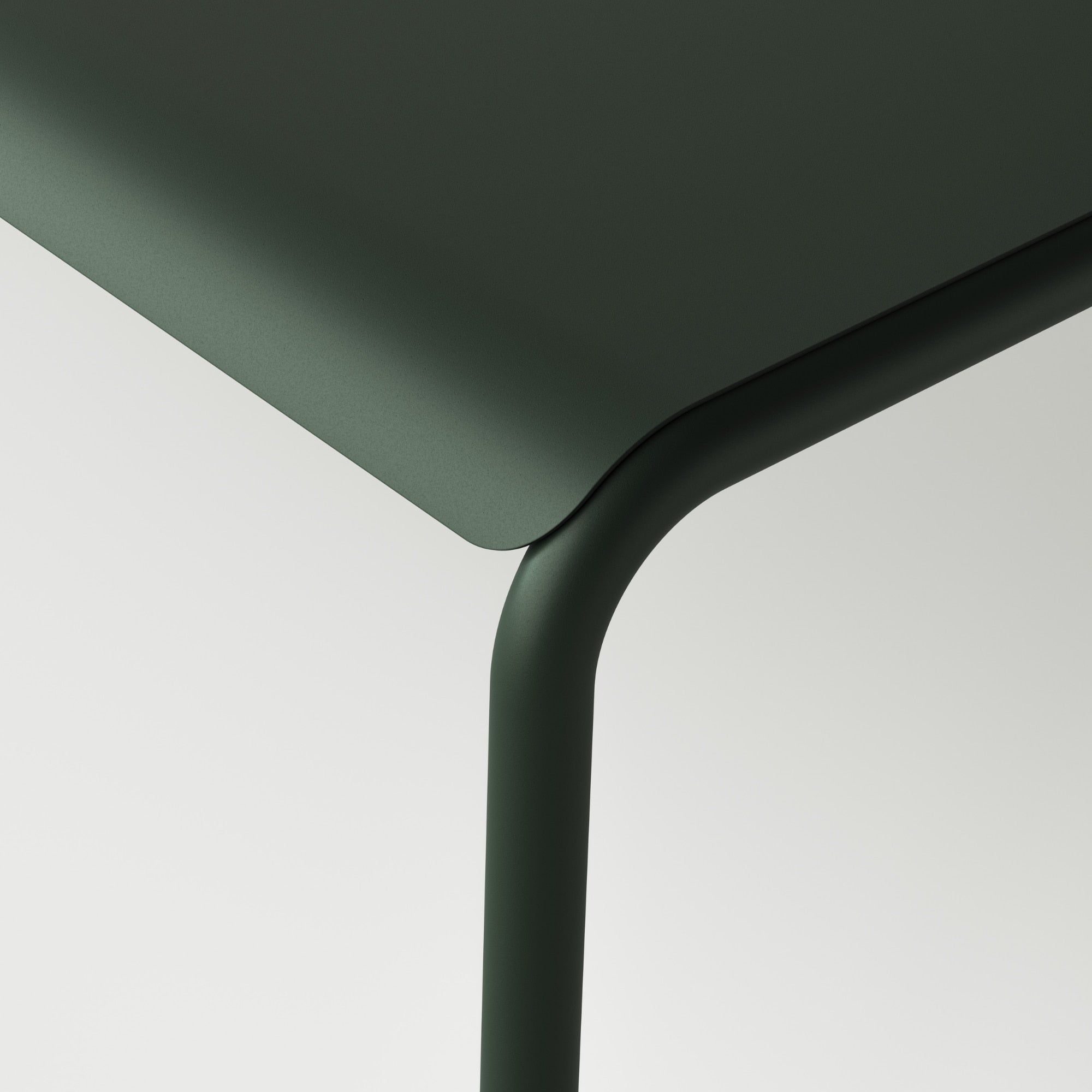 Gros plan sur le coin de la table de jardin, avec des bords arrondis en métal vert forêt, mettant en avant le design moderne et épuré du mobilier extérieur Tiptoe.