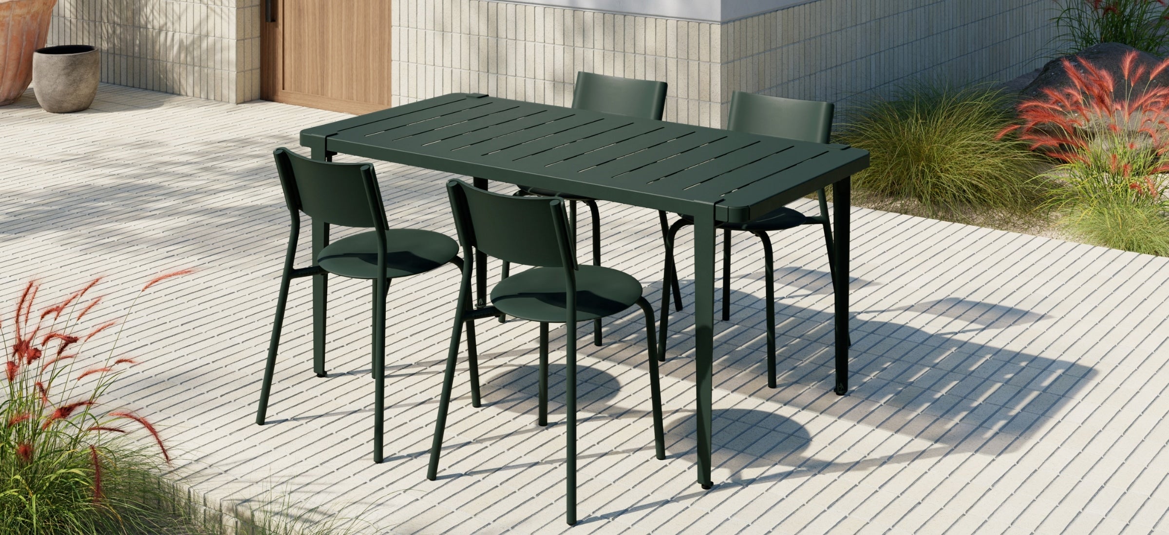 Table et chaises en métal et plastique recyclé vert foncé Tiptoe, mobilier d’extérieur, installé sur une terrasse contemporaine.