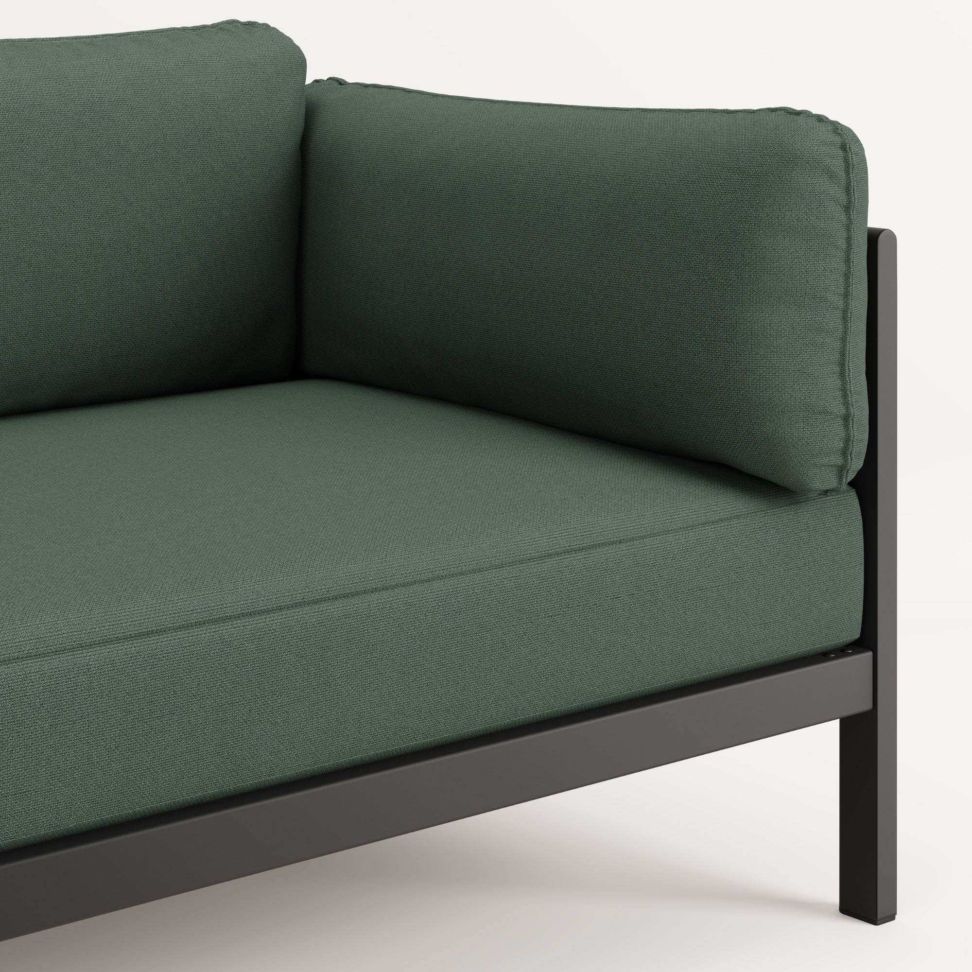 Zoom sur l’accoudoir et l’assise du canapé Easy en tissu vert forêt, structure en acier noir.